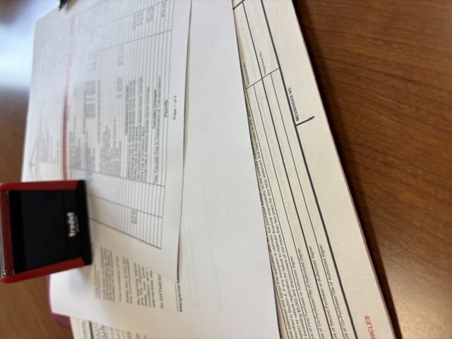 Closing documents, settlement statement, and notary stamp on the desk at an Absolute Mobile Home Closings settlement